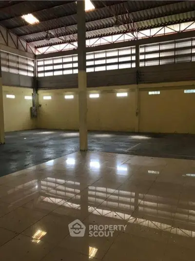 Spacious industrial warehouse with high ceilings and ample natural light.