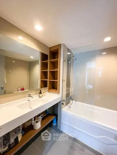 Modern bathroom with sleek design, featuring a bathtub and spacious vanity area.