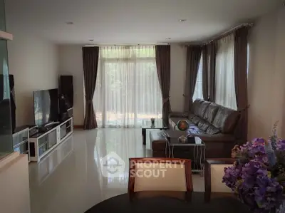 Spacious living room with modern decor and large windows offering natural light.