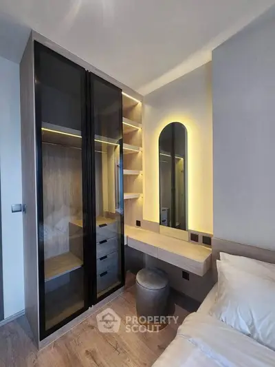 Modern bedroom with sleek wardrobe and illuminated vanity area