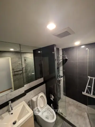 Modern bathroom with sleek design, featuring glass shower and stylish fixtures.