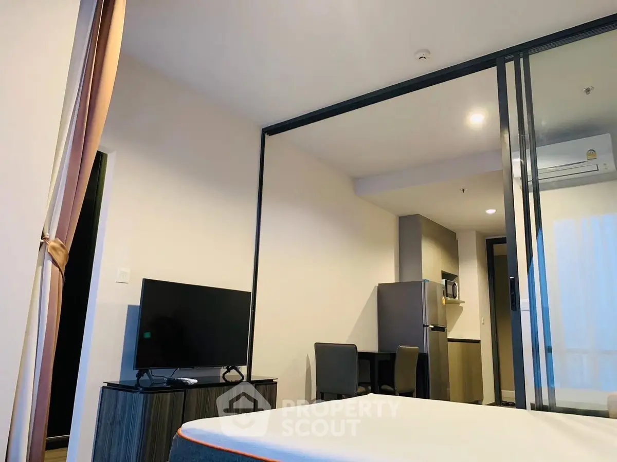 Modern studio apartment with sleek design, featuring a cozy living area and compact kitchen.