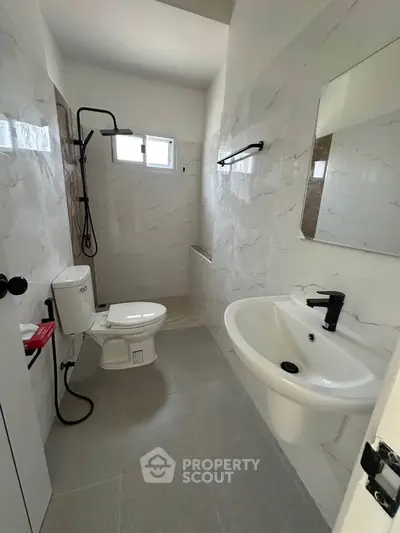 Modern bathroom with sleek fixtures and elegant tile design, featuring a shower and stylish sink.