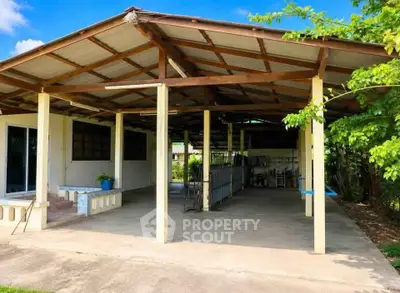 Spacious covered outdoor area with open layout and lush greenery.
