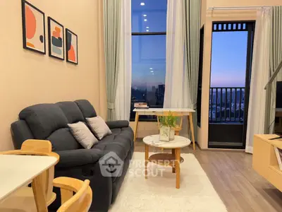 Modern living room with stylish decor and city view balcony at sunset.