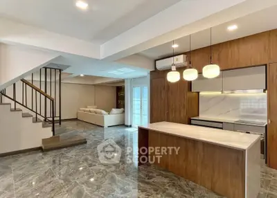 Spacious modern living room with open kitchen and elegant staircase