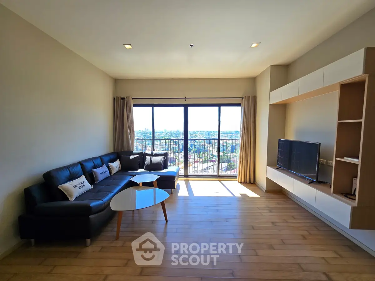 Spacious living room with modern decor and large windows offering stunning city views.