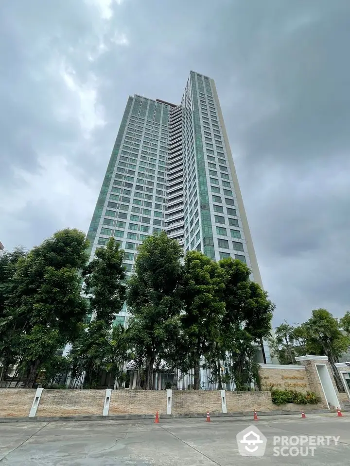 Stunning high-rise building with modern architecture and lush greenery at the base.