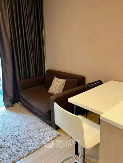 Cozy living room with modern sofa and stylish dining area in a compact apartment.