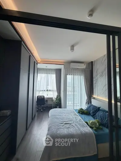 Modern bedroom with stylish decor and natural light, featuring a cozy bed and a work desk by the window.