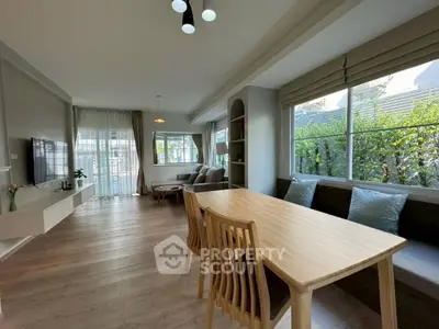Spacious modern living room with large windows and elegant dining area, perfect for family gatherings.