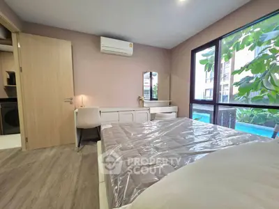 Modern bedroom with large windows and pool view, featuring stylish furniture and air conditioning.