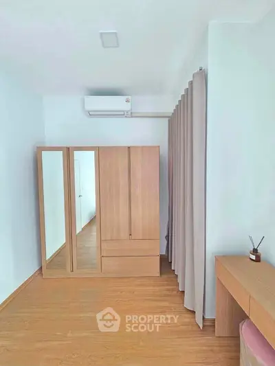 Spacious bedroom with wooden wardrobe and modern decor