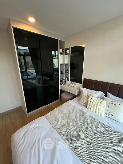 Modern bedroom with stylish decor and mirrored wardrobe