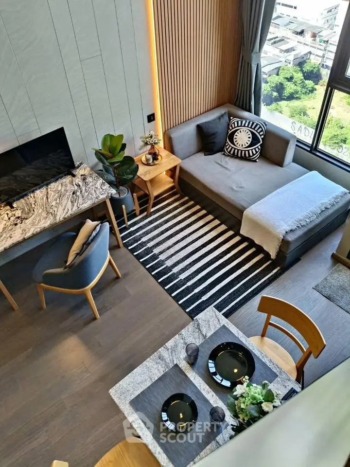 Modern living room with stylish decor and large window offering city view