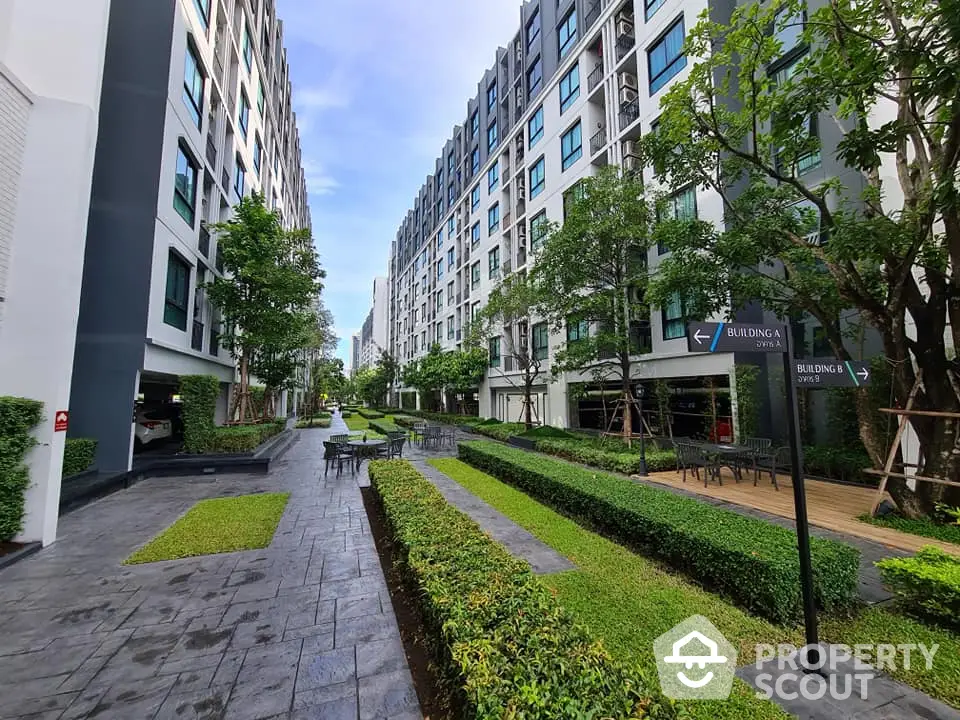 Modern residential complex with lush gardens and outdoor seating area