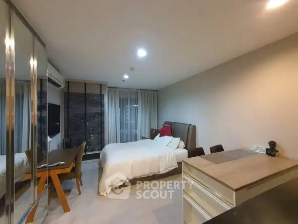 Modern bedroom with sleek design and mirrored wardrobe in a cozy apartment.
