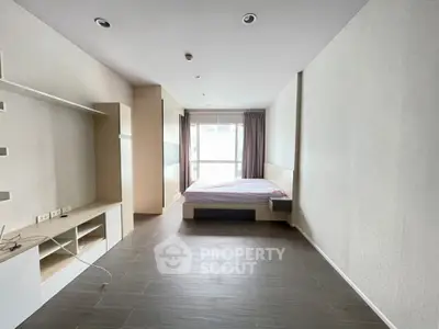 Spacious modern bedroom with minimalist design and large window for natural light