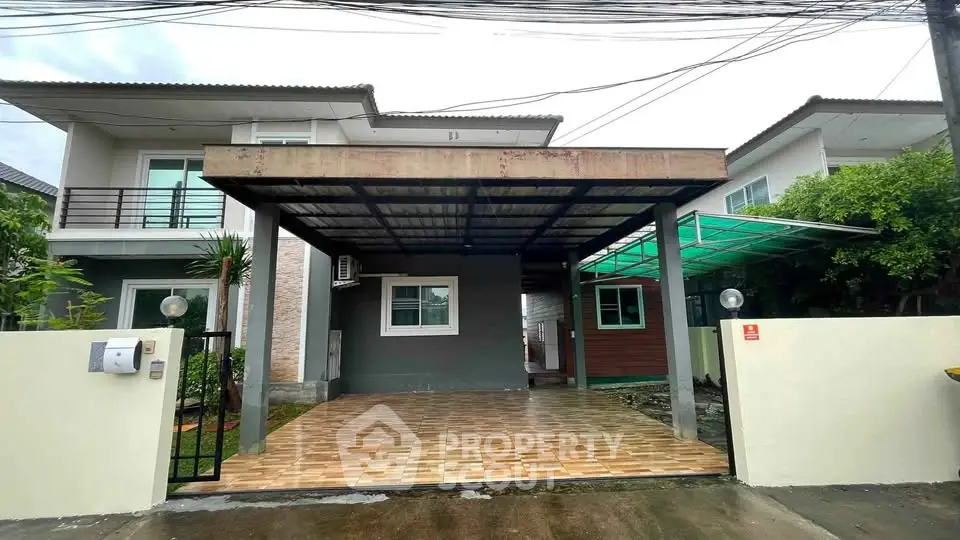 Modern two-story house with spacious carport and tiled driveway in a suburban neighborhood.