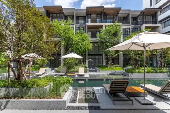 Luxurious apartment complex with serene pool and lush greenery