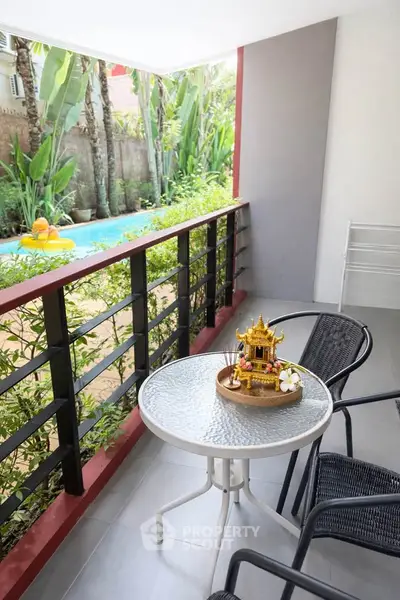 Charming balcony with pool view, perfect for relaxation and outdoor dining.