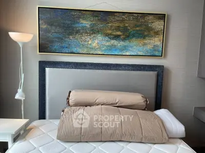 Stylish bedroom with modern art and cozy bedding in a contemporary setting.