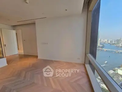 Spacious modern living room with stunning river view and elegant wooden flooring.