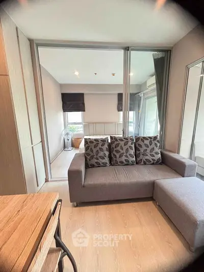 Modern living room with stylish gray sofa and wooden flooring