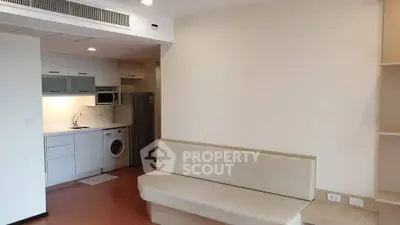 Modern studio apartment with compact kitchen and cozy living area, featuring built-in appliances and sleek design.