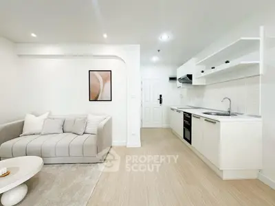 Modern open-layout living room with sleek kitchen, cozy sofa, and stylish decor in a bright apartment.
