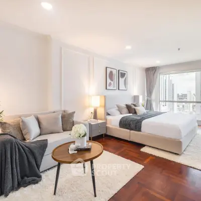 Luxurious bedroom with elegant decor and stunning city view, featuring cozy seating area and modern furnishings.
