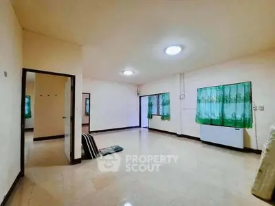 Spacious empty living room with tiled floor and green curtains, ready for customization.