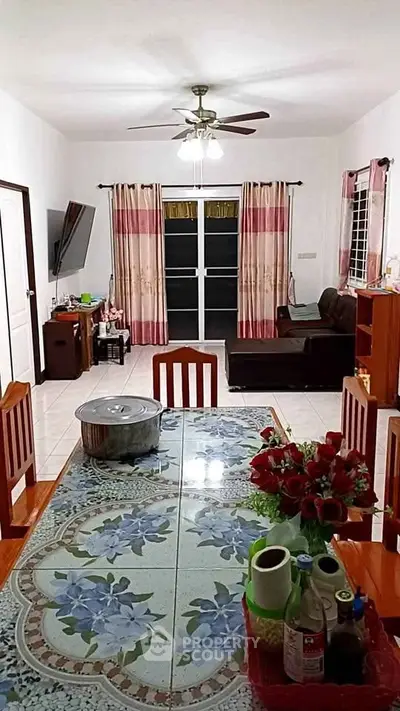 Spacious living room with dining area, featuring floral table decor and cozy seating, ideal for family gatherings.