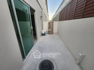 Modern outdoor patio with sliding glass doors and privacy fence