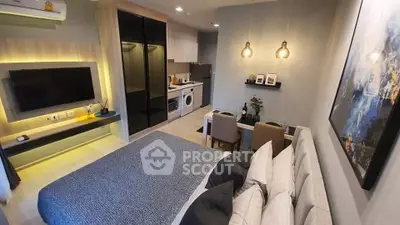 Modern studio apartment with stylish decor and compact kitchen area.