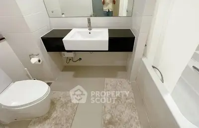 Modern bathroom with sleek fixtures and bathtub in a contemporary apartment.
