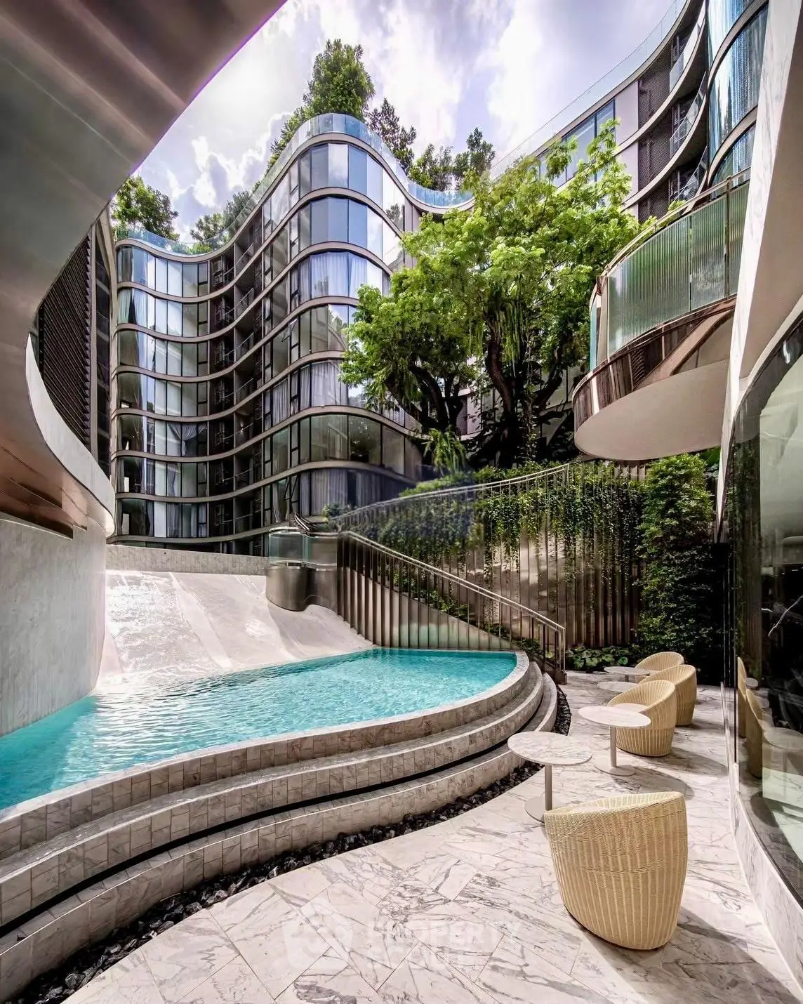 Luxurious modern building with stunning pool and elegant outdoor seating area.