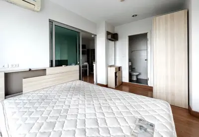 Spacious bedroom with modern furnishings and natural light in a stylish apartment.