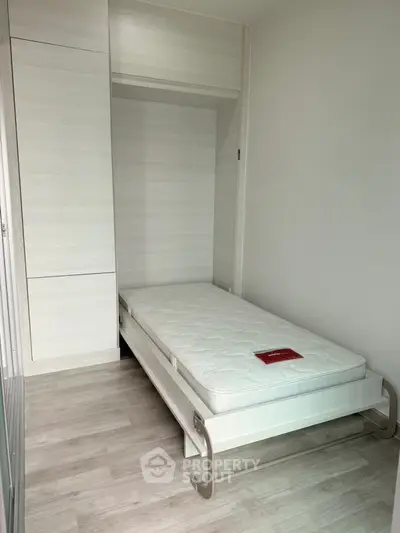 Compact bedroom with single bed and built-in wardrobe, ideal for minimalist living.