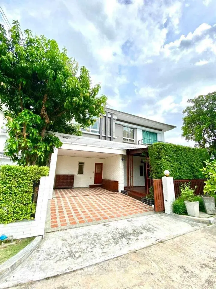 Modern two-story house with spacious driveway and lush greenery