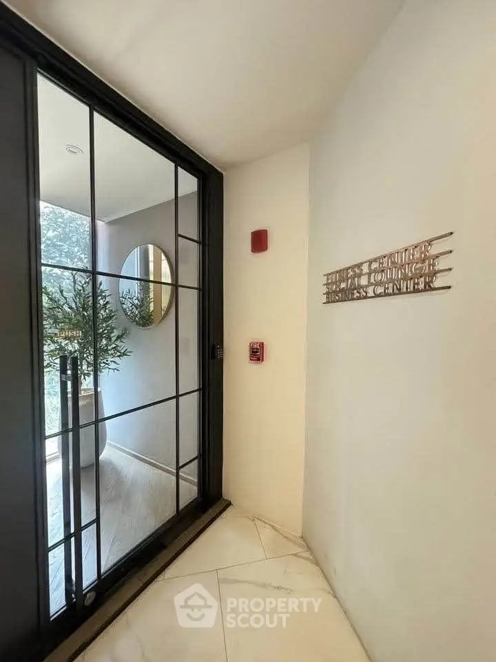 Elegant entrance to a modern business center with sleek glass doors and stylish decor.