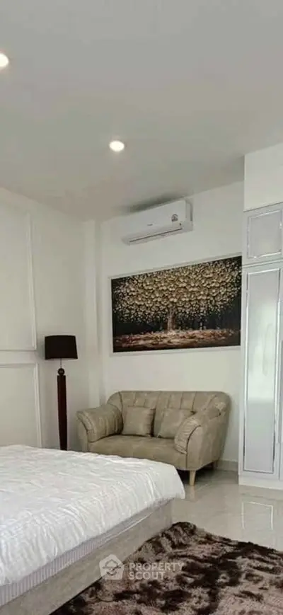 Cozy bedroom with stylish decor and comfortable seating area