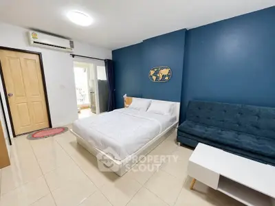 Modern bedroom with blue accent wall and cozy furnishings