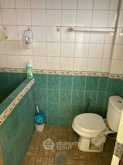 Cozy bathroom with tiled walls and essential amenities, perfect for a compact living space.