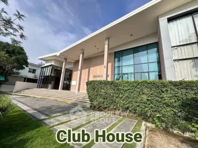Modern clubhouse exterior with large windows and lush greenery, perfect for community gatherings.