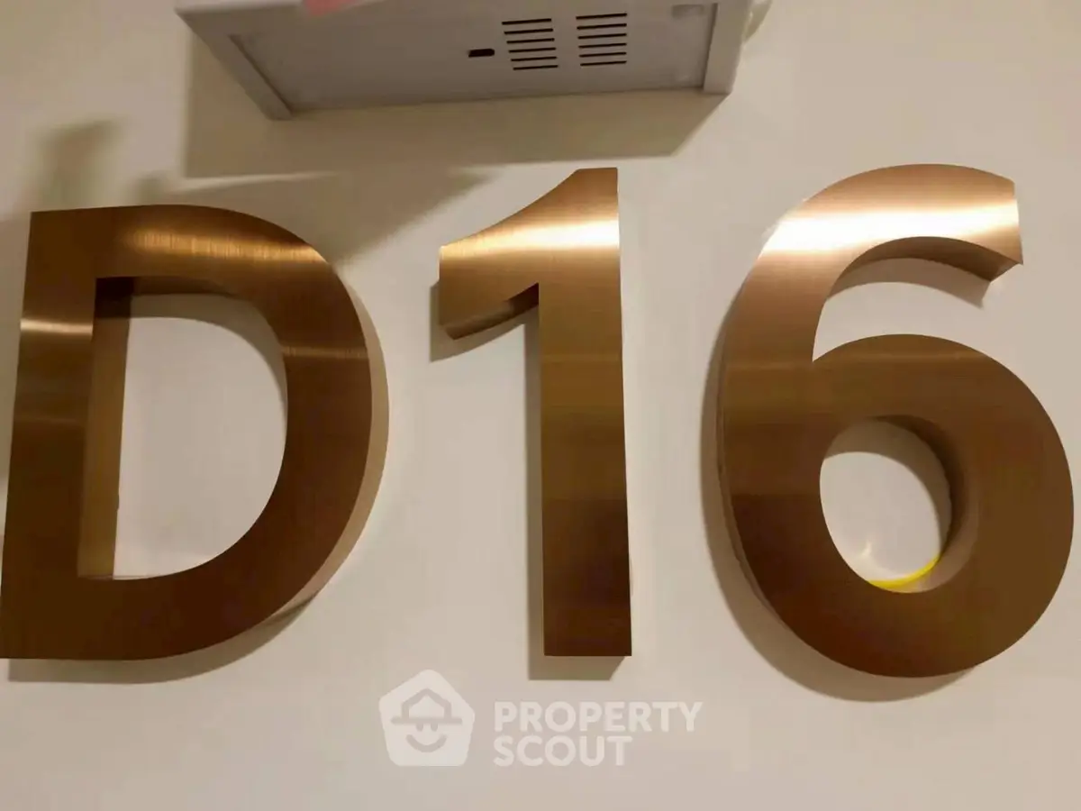 Modern apartment unit number D16 in sleek metallic finish