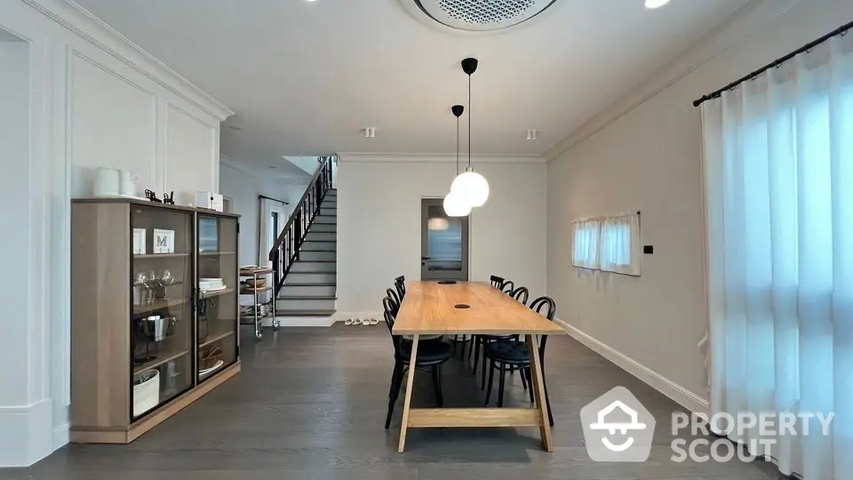 Elegant dining room with modern wooden table and stylish chairs in a spacious interior