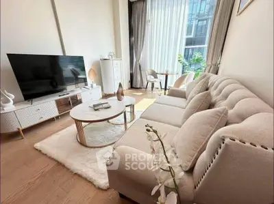 Elegant living room with modern decor, large TV, and natural light from floor-to-ceiling windows.