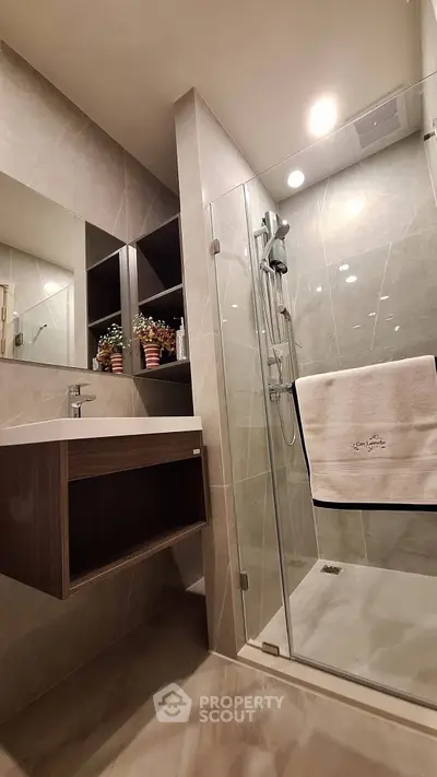 Modern bathroom with sleek shower and elegant vanity in luxury apartment