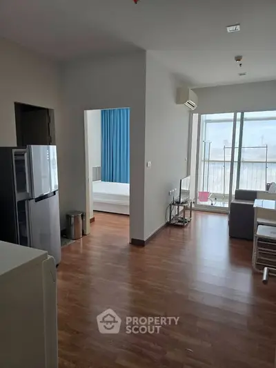 Modern apartment interior with wooden flooring and balcony view